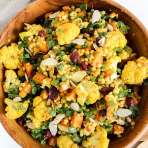 overview shot of curry roasted cauliflower couscous salad in a wooden bowl