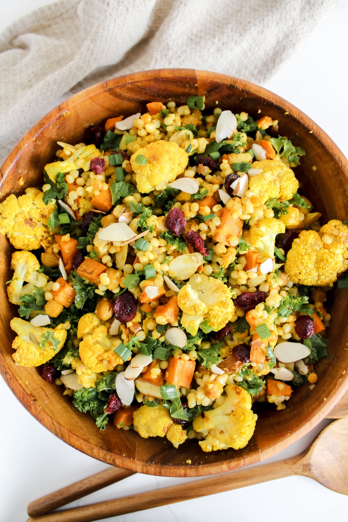 overview shot of curry roasted cauliflower couscous salad in a wooden bowl