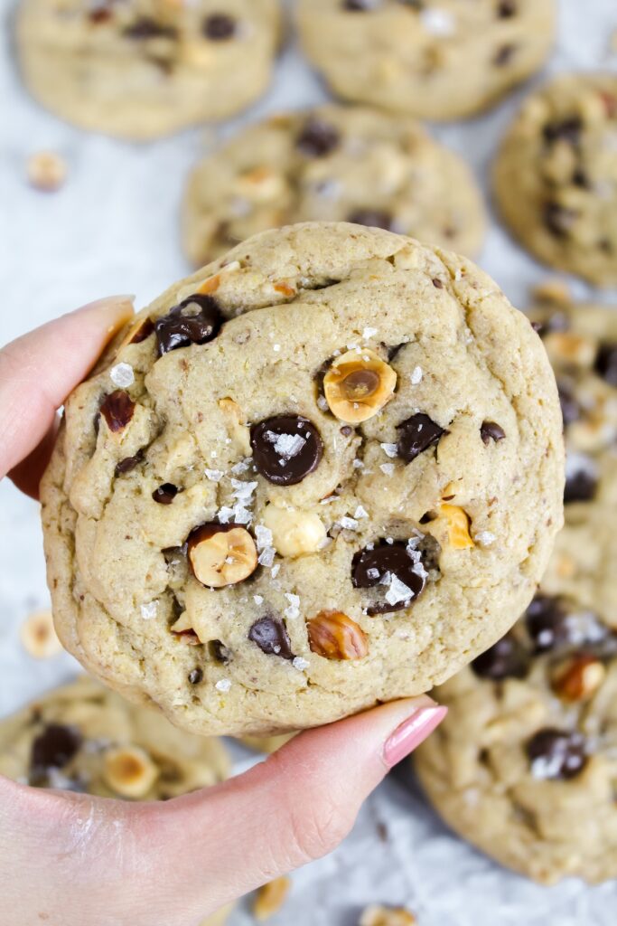 hand holding a vegan hazelnut chocolate chip cookie