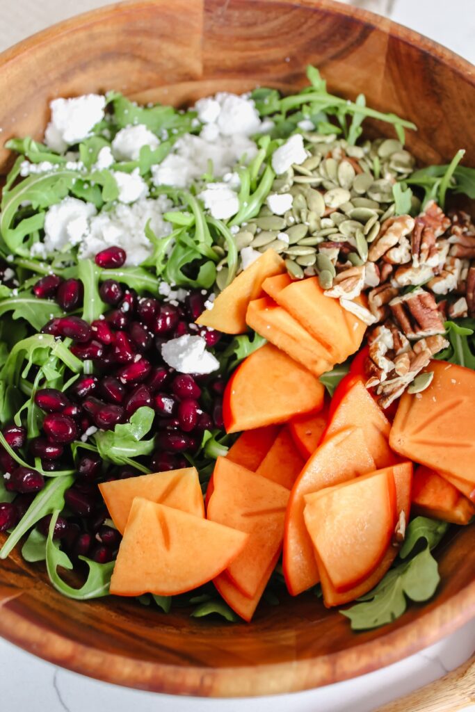 all the salad ingredients separated in a wooden bowl