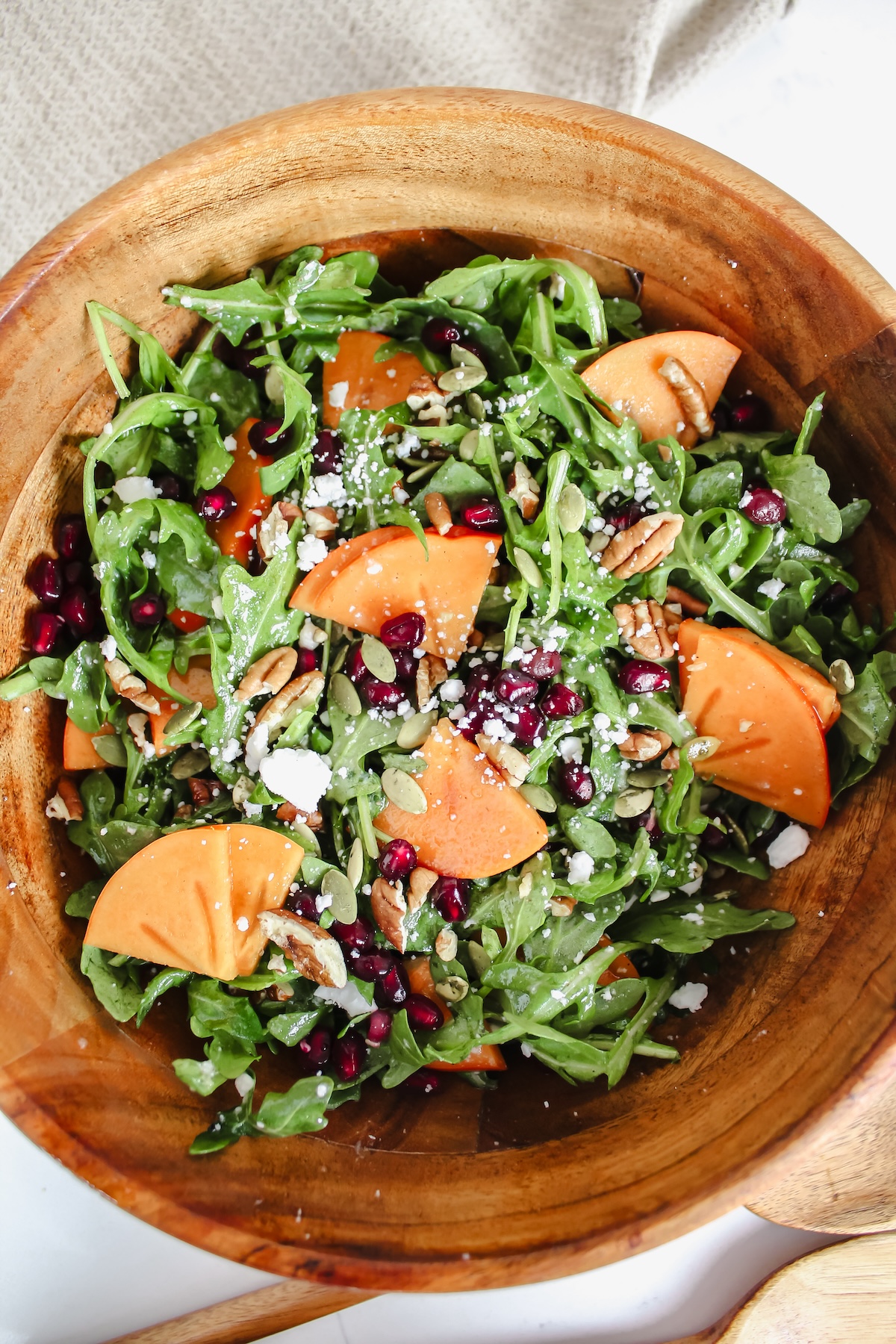 overview shot of persimmon pomegranate arugula salad