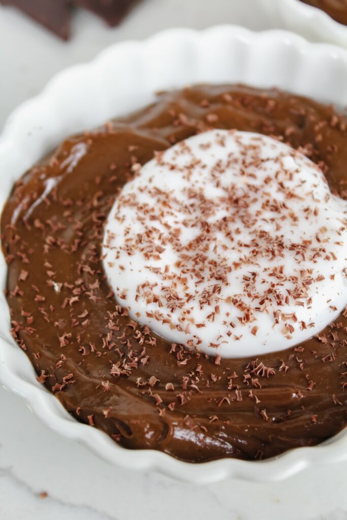 close up shot of chocolate avocado pudding with coconut yogurt on top