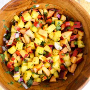 overview shot of pineapple peach salsa in wooden bowl