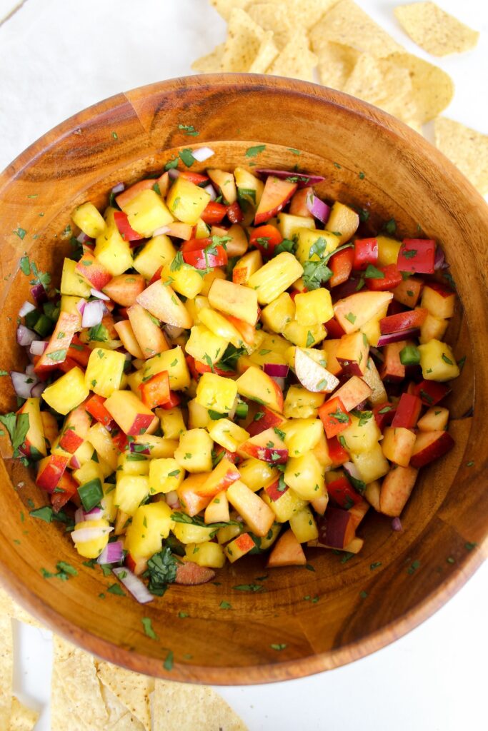 overview shot of pineapple peach salsa in wooden bowl