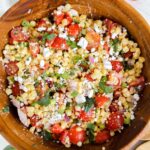 tomato corn feta salad in a wooden bowl