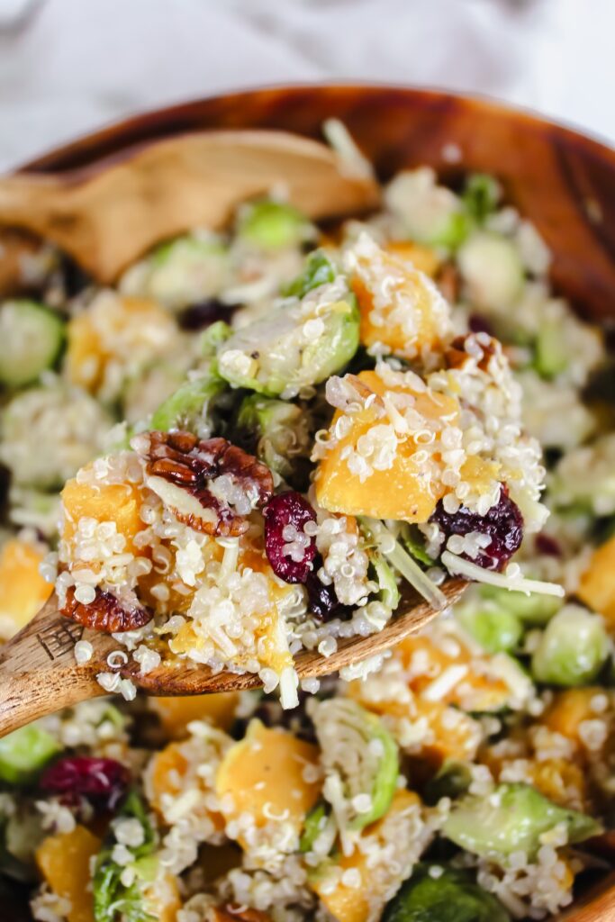 a scoop of quinoa salad on a wooden spoon