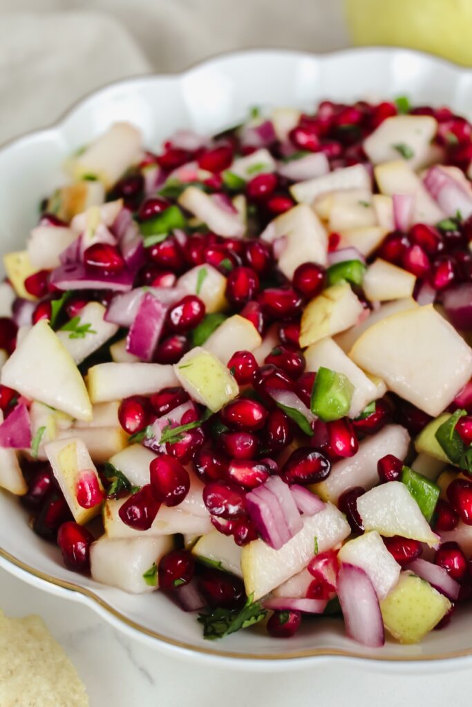angled shot of pear pomegranate salsa in a white bowl