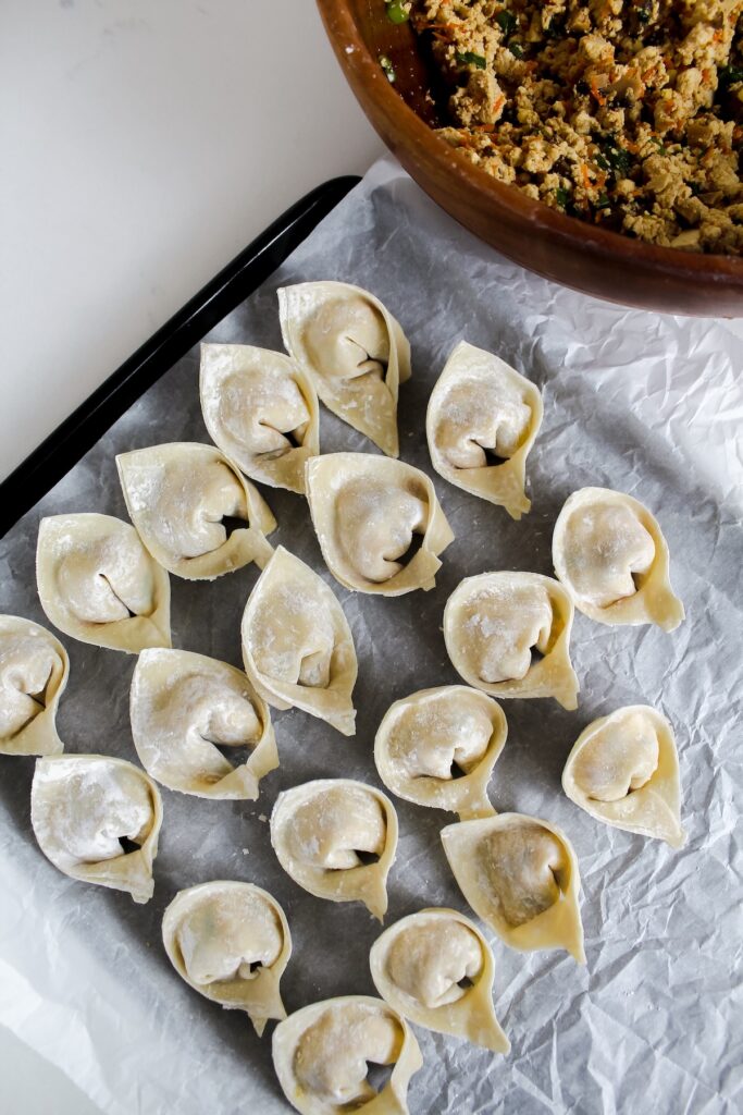 uncooked wrapped wontons a baking sheet