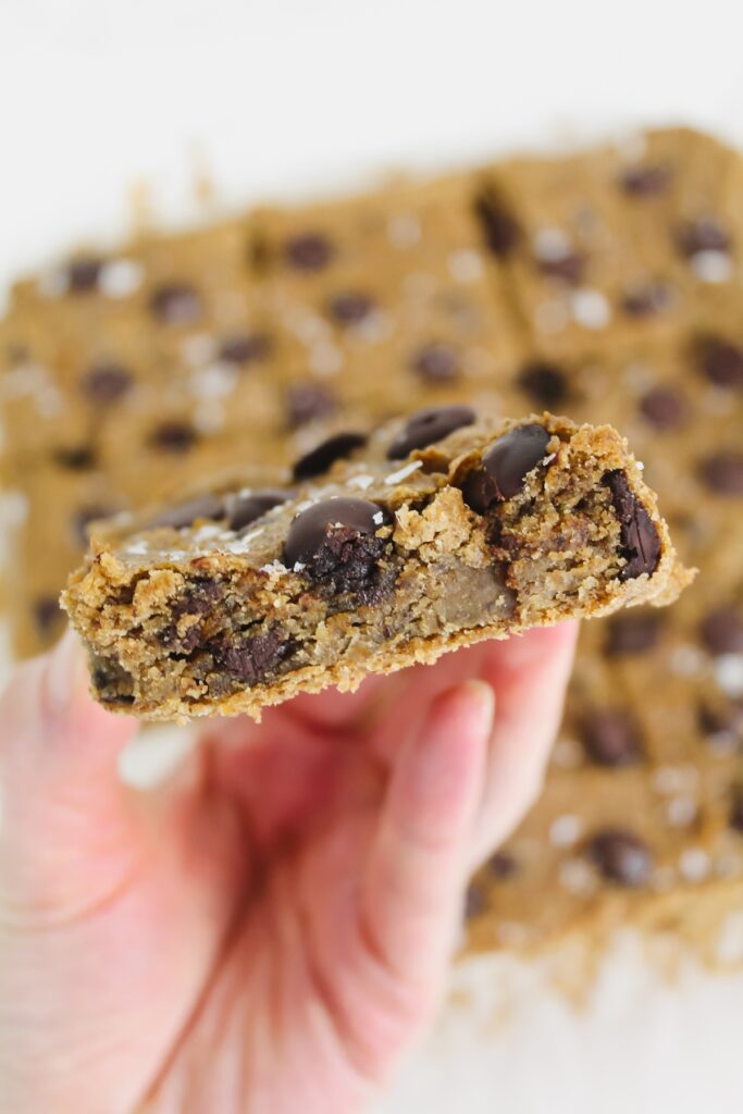 hand holding a slice of chickpea peanut butter chocolate chip blondies