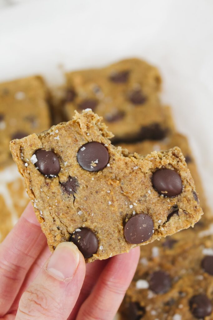 hand holding a blondie with a bite taken out of it