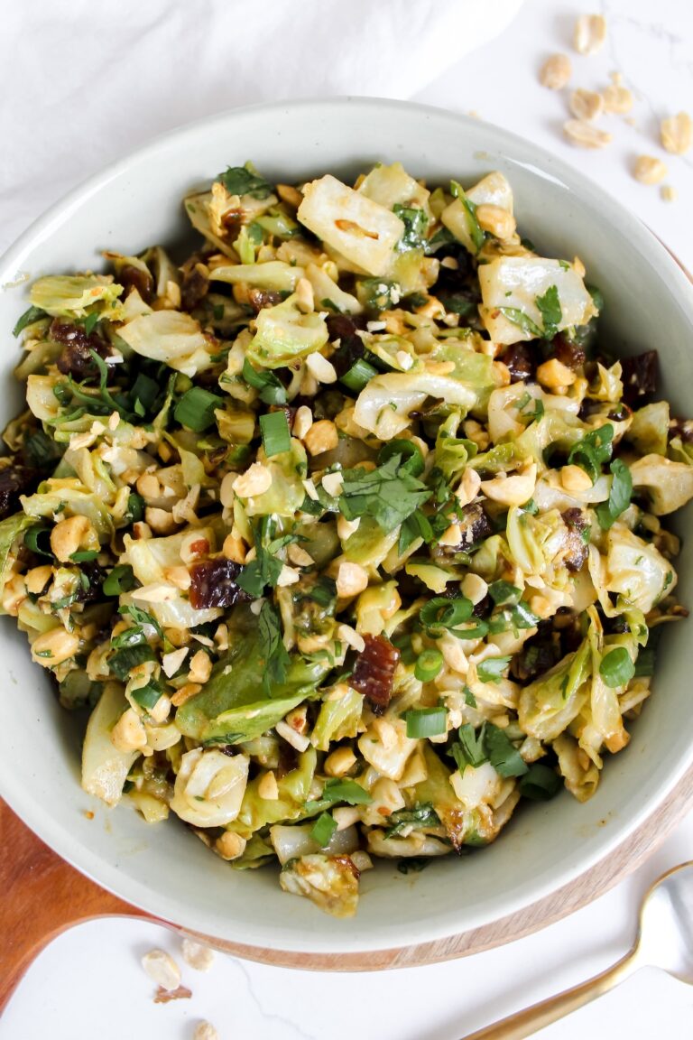 overview shot of roasted cabbage peanut date salad in a white bowl