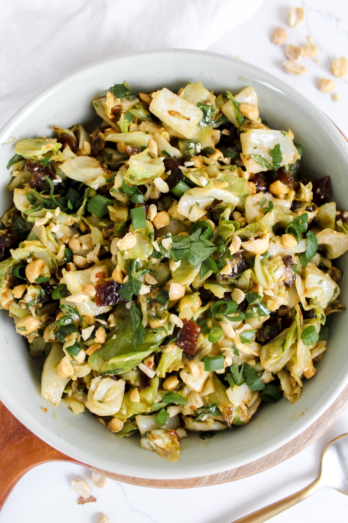overview shot of roasted cabbage peanut date salad in a white bowl