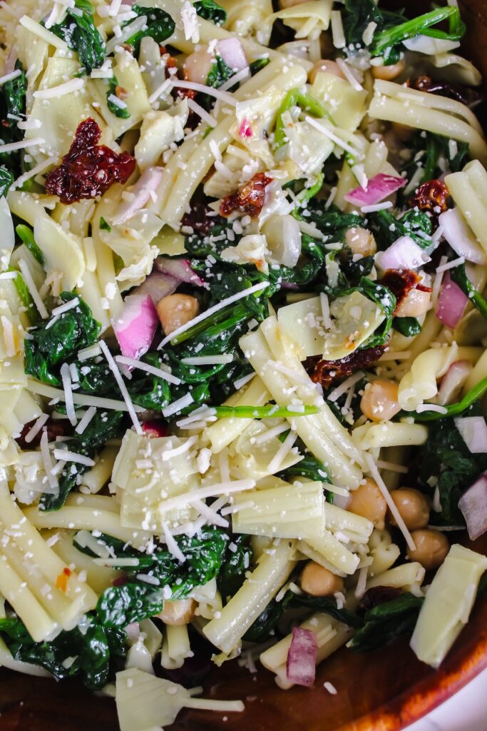 close up shot of spinach artichoke pasta salad