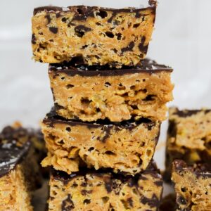 chocolate peanut butter protein cornflake bars stacked on top of each other