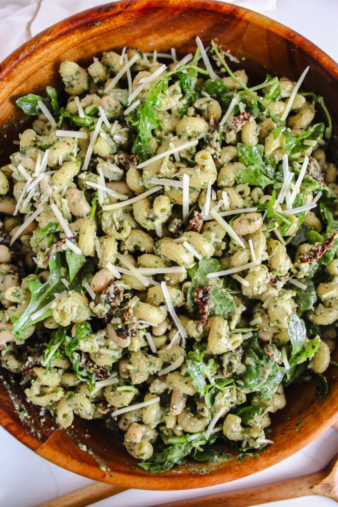 overview shot of wooden bowl with the best pesto pasta salad