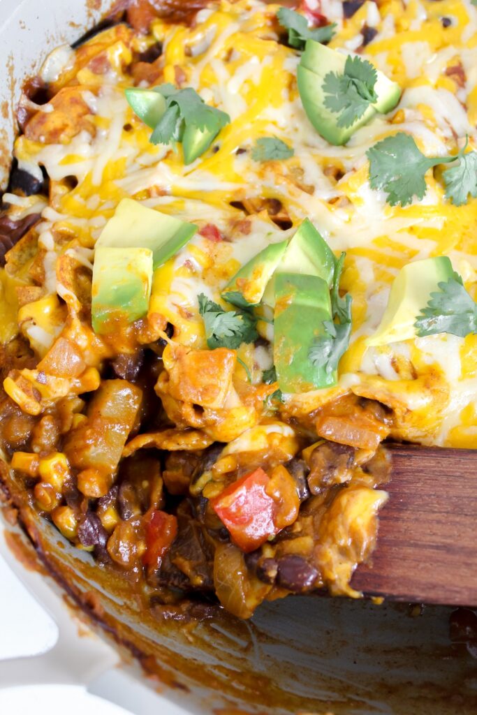 close up shot of wooden spatula in the vegan skillet enchiladas