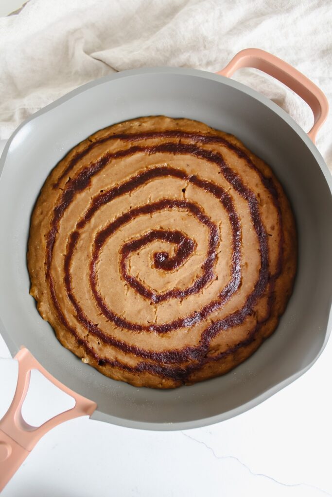 giant pumpkin cinnamon roll pancake in a skillet