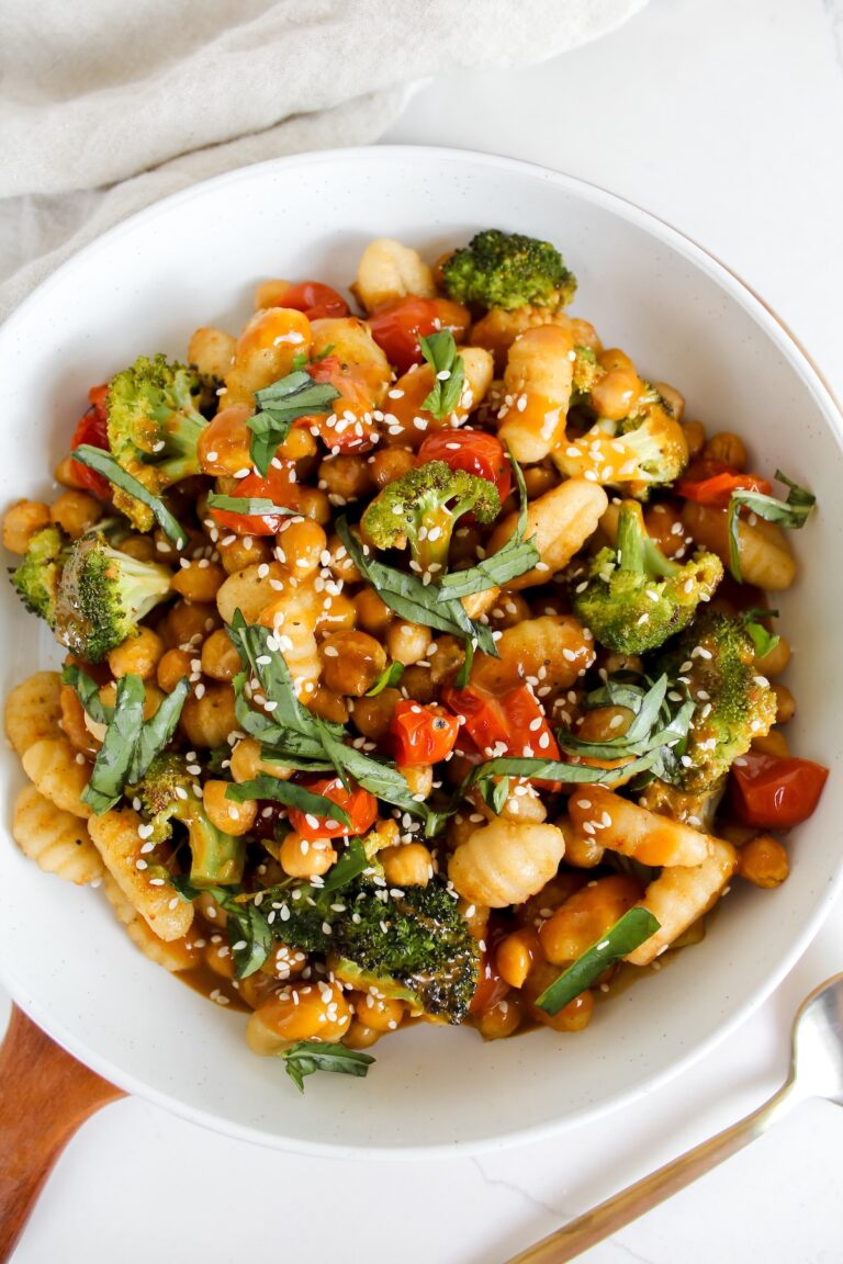 overview shot of bowl of sheet pan gnocchi and veggies with sauce on top